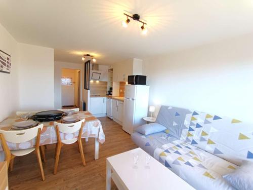 un salon avec un canapé et une table et une cuisine dans l'établissement Studio lumineux 4 pers, balcon, Pla d'Adet - FR-1-457-363, à Saint-Lary-Soulan
