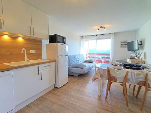 Il dispose d'une cuisine et d'un salon avec une table et un réfrigérateur. dans l'établissement Studio lumineux 4 pers, balcon, Pla d'Adet - FR-1-457-363, à Saint-Lary-Soulan