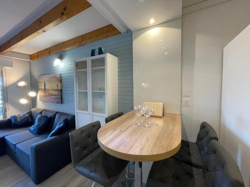 une salle à manger avec une table et un canapé dans l'établissement Duplex T2 avec Piscine à Capbreton proche Plage - FR-1-413-250, à Capbreton