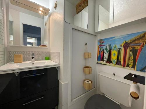 La salle de bains est pourvue d'un lavabo et de toilettes avec une peinture. dans l'établissement Duplex T2 avec Piscine à Capbreton proche Plage - FR-1-413-250, à Capbreton