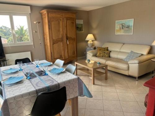 un salon avec une table et un canapé dans l'établissement Bel appartement T3 à St Aygulf, climatisé, proche plage, parking privé - FR-1-768-110, à Fréjus