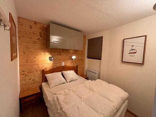 - une petite chambre avec un lit et un mur en bois dans l'établissement Charmant 2 pièces avec balcon pour 4 personnes à Avoriaz - FR-1-634-106, à Morzine