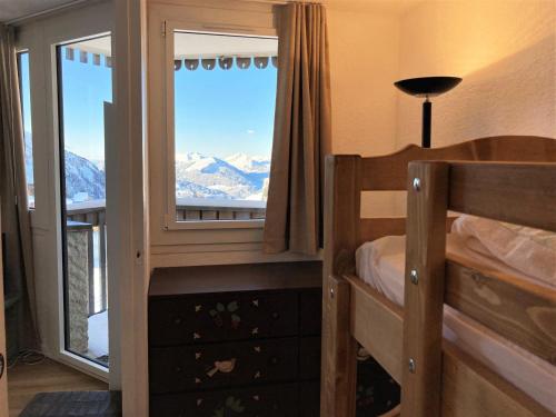 - une chambre avec des lits superposés et une fenêtre donnant sur les montagnes dans l'établissement Confort 2 pièces sud - wifi, vues magnifiques - FR-1-634-108, à Morzine