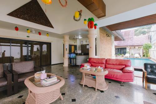 a living room with a red couch and a table at Royal Prince Residence, Patong Beach in Patong Beach