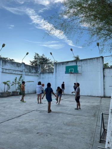 a group of children playing basketball on a court at Nacho Hostel Cebu in Bulacao
