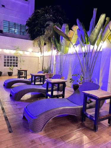 a room with purple chairs and tables and plants at Nacho Hostel Cebu in Bulacao