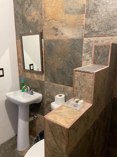 a bathroom with a sink and a toilet and a mirror at Hotel Yalnazac Mitla in San Pablo Villa de Mitla