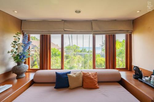 a living room with a couch and a large window at Nakamanda Resort and Spa in Klong Muang Beach