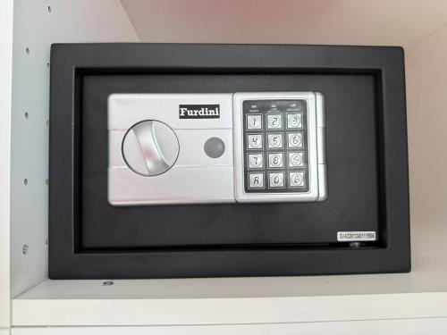 a television with a remote control on a wall at TN KAMALA Room For Rent in Kamala Beach