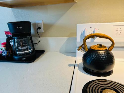 a tea kettle on a stove with a coffee maker at Mad Men in Salem