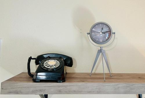 a phone sitting on a table next to a clock at Mad Men in Salem