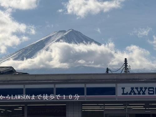a snowcovered mountain behind a building with a train at 道龍house in Azagawa