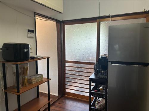 a kitchen with a stainless steel refrigerator and a window at Japanese house -Vacation stay- in Saitama