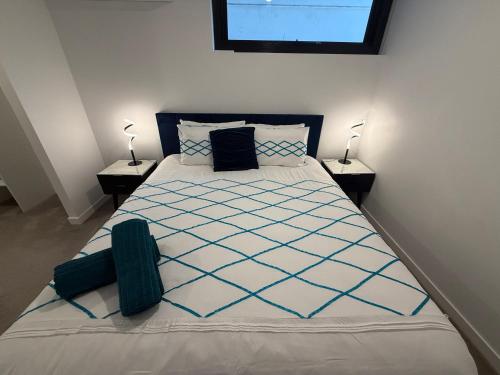 a bedroom with a large bed with blue and white sheets at Midnight Luxe 2BR 2Bath 2Car 230 Pool Gym Sauna in Canberra