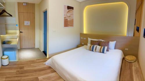 a bedroom with a large white bed and a bathroom at Sunlight Heyun B&B in Yuanshan