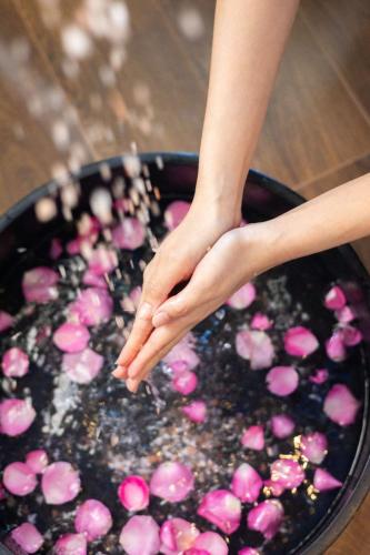 a person holding their hand in a pan filled with pink cookies at The Soul Resort in Sara Buri
