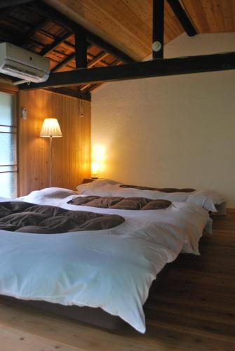 a bedroom with two beds with white sheets and a lamp at AZAE Kyoto Japan in Shūzan