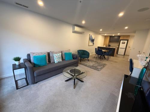 a living room with a couch and a table at Midnight Luxe 2BR 2Bath 2Car 230 Pool Gym Sauna in Canberra