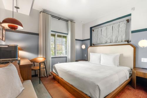 une chambre avec un lit, un bureau et une télévision dans l'établissement The Daydrift, à Miami Beach