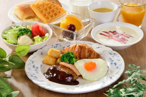 a table topped with a plate of breakfast food at Fukui Manten Hotel Ekimae in Fukui