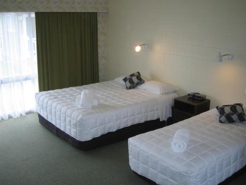 um quarto de hotel com duas camas e uma janela em RossMotels em Ross