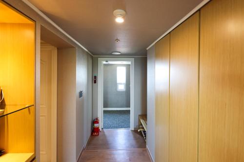 a hallway with yellow walls and wooden cabinets at La Vie Dor Hotel and Resort, Trademark Collection by Wyndham in Hwaseong