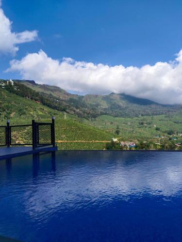 a large body of water with a view of a mountain at Silver cascade in Devikolam