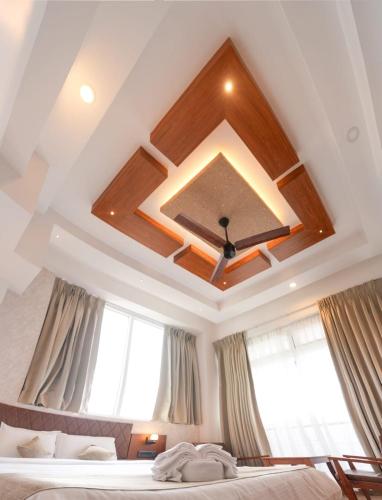 a bedroom with a coffered ceiling and a bed with windows at Silver cascade in Devikolam