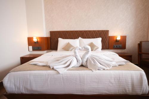 two swans are wrapped in towels on a bed at Silver cascade in Devikolam