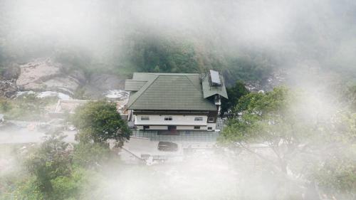 a house on top of a mountain in the clouds at Silver cascade in Devikolam