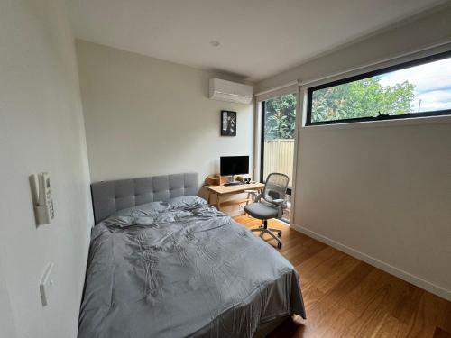 a bedroom with a bed and a desk and a window at Quiet and Cozy corner in Braybrook