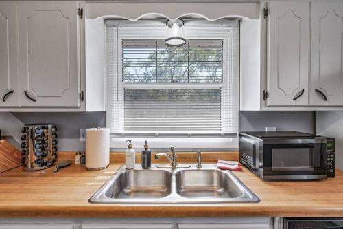 a kitchen with a sink and a microwave at Tranquil 2BR Apt Mpls - 8075 Apt 4 in Spring Lake Park