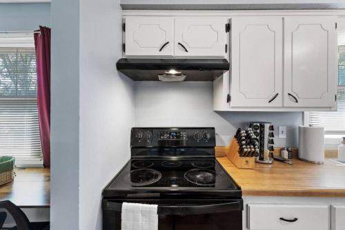 a kitchen with a black stove and white cabinets at Tranquil 2BR Apt Mpls - 8075 Apt 4 in Spring Lake Park
