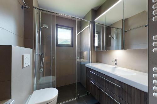 a bathroom with a toilet and a sink and a shower at Apartment Larschigna in Zuoz