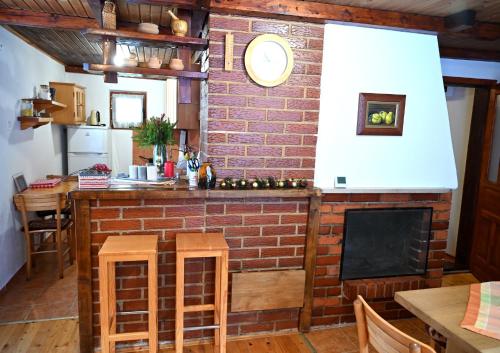 a kitchen with a brick wall and a fireplace at Vikendica Mašan in Pale