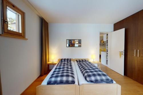 a bed in a room with two pillows on it at Apartment Belvair 3 in Zuoz