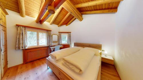 シルス・マリアにあるApartment Alveternの木製の天井の部屋にあるベッドのある寝室