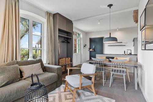 a living room and kitchen with a couch and a table at Alte Schule Westerhever Tholendorf in Westerhever