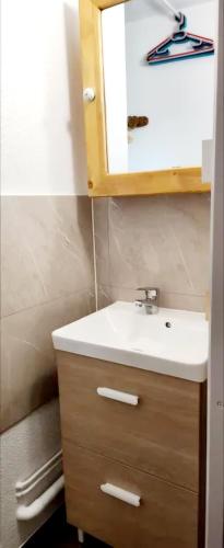 une salle de bain avec un lavabo et un miroir dans l'établissement Manigod Ski Sun, à Manigod