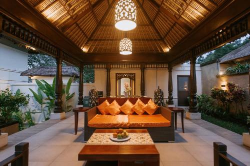 an outdoor patio with a couch and a table at Villa Anggrek Jimbaran in Jimbaran