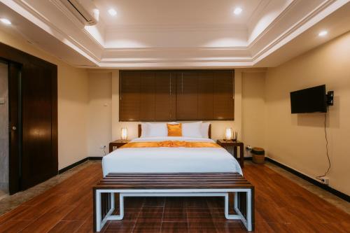 a bedroom with a bed and a flat screen tv at Villa Anggrek Jimbaran in Jimbaran