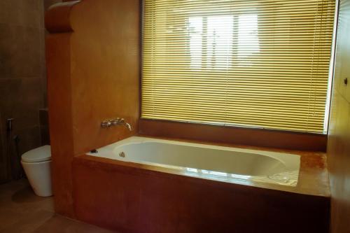 a bath tub in a bathroom with a window at Dream Lagoon in Katunayake