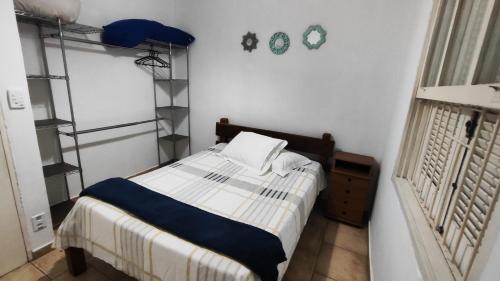 - une petite chambre avec un lit et une étagère dans l'établissement Casa com Piscina 200 m da Praia - São Sebastião, à São Sebastião