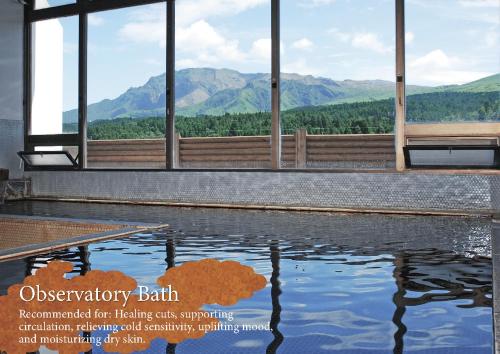 a pool of water with mountains in the background at Kamenoi Hotel Aso Park Resort in Aso