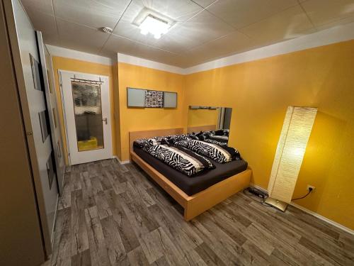 a bedroom with a bed in a room with yellow walls at Ruhige Toplage im Zentrum in Karlsruhe