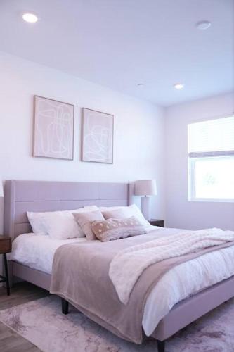 a white bedroom with a bed and a window at Modern Townhouse with Mountain View near Ventura Beach in Ventura