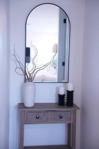 a dressing table with a mirror and a vase on it at Modern Townhouse with Mountain View near Ventura Beach in Ventura