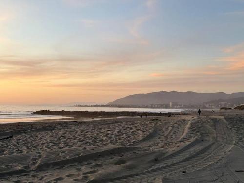 a beach with people walking on the sand at Modern Townhouse with Mountain View near Ventura Beach in Ventura
