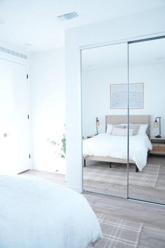 a white bedroom with a bed and a mirror at Modern Townhouse with Mountain View near Ventura Beach in Ventura