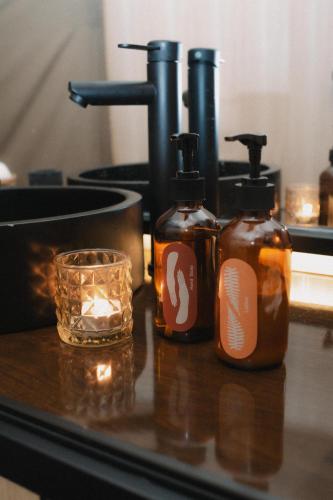 two bottles of soap on a counter with a candle at RINDANG Glamping in Tlekung